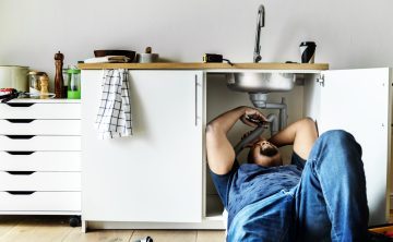 plumber-man-fixing-kitchen-sink-scaled-q9g3kdlnnm0qe2j6ieq6slc0n93tw6x5itmb7em2zw